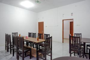 a dining room with a wooden table and chairs at RedDoorz near Pasar Baru Mamuju in Mamuju