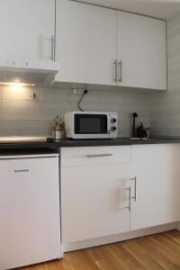 a kitchen with white cabinets and a microwave at SR Costa del Sol Miraflores in La Cala de Mijas
