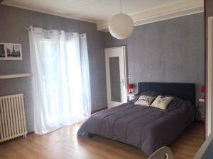 a bedroom with a bed and a large window at MAISON BELLEVUE 3 étoiles 4 à 10P in Laruns