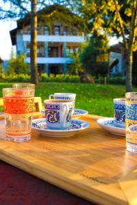 a wooden table with tea cups and glasses on it at Rif Sapanca - Adult Only in Sapanca