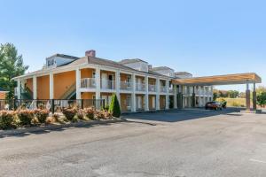 un gran edificio con un coche aparcado en la entrada en Quality Inn Johnson City I-26 exit 17, en Johnson City