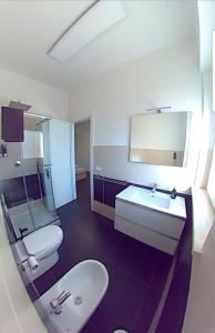 ein Badezimmer mit einem Waschbecken, einem WC und einem Spiegel in der Unterkunft Efeso 19 in Rom