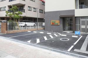 越谷市にあるHotel Sun Clover Koshigaya Station - Vacation STAY 55366の建物前の空き駐車場