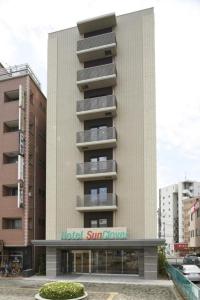越谷市にあるHotel Sun Clover Koshigaya Station - Vacation STAY 55366のホテルの日焼け止めの看板が貼られた建物