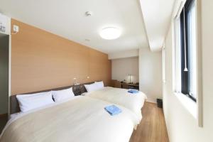 越谷市にあるHotel Sun Clover Koshigaya Station - Vacation STAY 55377の窓のある部屋に白いベッドが2つある +18枚の写真