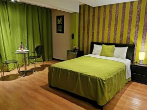 a bedroom with a bed with green curtains and a table at Fantasy Suites in Lima