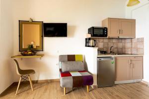 a small kitchen with a chair and a table and a sink at Yaliskari Beach in Pelekas
