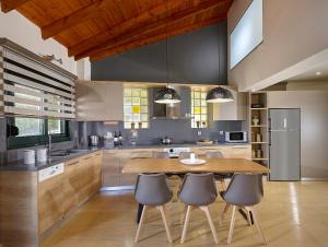 a large kitchen with a wooden table and chairs at Villa Thallos in Gouves