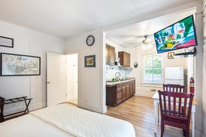 1 dormitorio con cama, escritorio y cocina en Four Flowers Guesthouse, en Key West