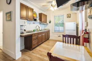 a kitchen with wooden cabinets and a dining table at Four Flowers Guesthouse in Key West