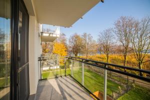 a balcony with a view of trees and grass at Apart Harmony - Apartamenty Nexo in Puck