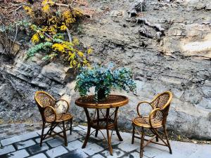 a table with three chairs and a vase on it at Funicular Inn Apartments in Tbilisi City +84 photos