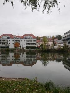 un reflejo de edificios en una masa de agua en Atelier des Poèmes. en Montbéliard