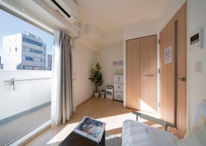 una sala de estar con una ventana grande y una habitación en Meet Me Umeda Nishi, en Osaka 171 fotos más