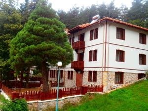 a large white building with a tree in front of it at Hotel Mitnitsa and TKZS Biliantsi in Arda