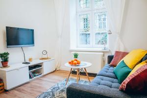 uma sala de estar com um sofá e uma mesa com fruta em Cosy Apartment em Cracóvia