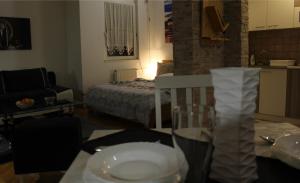 una sala de estar con una cama y una mesa con una copa de vino en Two Kings apartment en Novi Sad