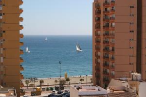 
a large body of water with buildings and boats at Apartamentos Embajador in Fuengirola

