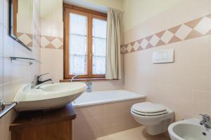 Un baño blanco con lavabo e inodoro. en Villa S. Francesco - Stayincortina, en Cortina dʼAmpezzo 4 fotos más