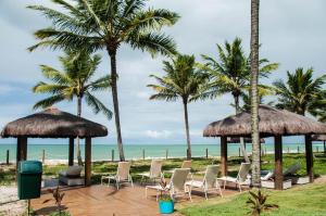 - une plage avec des chaises, des palmiers et l'océan dans l'établissement OKA Beach Resort, à Porto de Galinhas