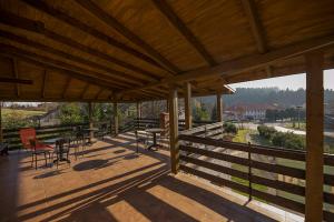 a large wooden deck with chairs and tables on it at Pod Bocianim Gniazdem in Ropienka
