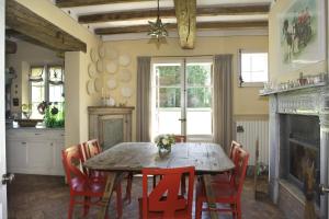 a dining room with a wooden table and red chairs at B&B Cà Bianca dell'Abbadessa in San Lazzaro di Savena