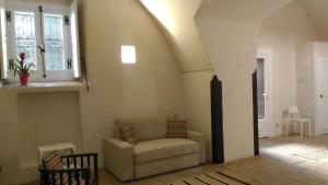 een woonkamer met een bank en een raam bij Palazzo Rossi suite in Canosa di Puglia