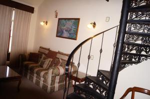 a living room with a couch and a spiral staircase at Hotel Hacienda de los Ángeles by Rotamundos in Comitán