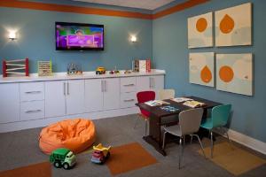 a dining room with a table and a tv on a wall at Furnished Quarters at 15/25 Bank Street in White Plains