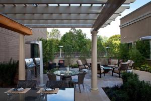 a patio with a table and chairs and a grill at Furnished Quarters at 15/25 Bank Street in White Plains