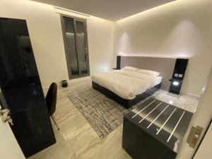 a bedroom with a bed and a table in it at Sadan Furnished Apartments in Riyadh