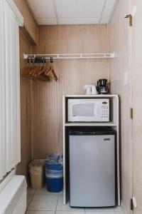 uma cozinha com um micro-ondas em cima de um frigorífico em Heart of Wildwood Motel em Wildwood