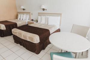 um quarto de hotel com duas camas e uma mesa em Heart of Wildwood Motel em Wildwood