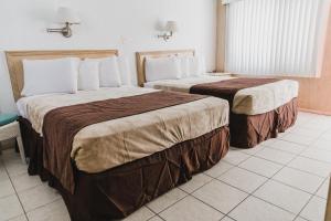 duas camas num quarto de hotel ao lado um do outro em Heart of Wildwood Motel em Wildwood