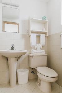 a white bathroom with a toilet and a sink at Heart of Wildwood Motel in Wildwood