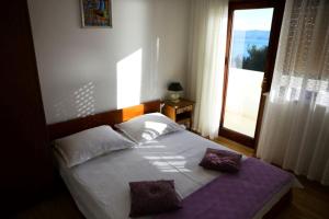 a bedroom with a large bed with a window at Apartments STANIĆ - apartments with a view of the sea and sandy beach in Duće