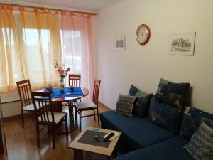 - un salon avec un canapé bleu et une table dans l'établissement APARTMAN NENA, à Karlovac