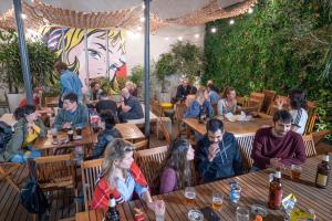 un grupo de personas sentadas en mesas en un restaurante en America Del Sur Hostel Buenos Aires, en Buenos Aires