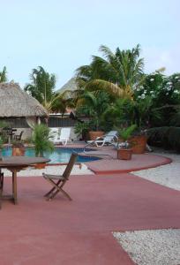 a resort with a pool and a table and chairs at Cunucu Villas - Aruba Tropical Garden Apartments in Oranjestad