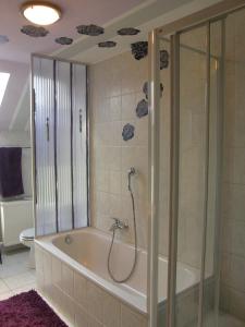 La salle de bains est pourvue d'une baignoire et d'une douche. dans l'établissement Land & Stil, à Dorfhagen
