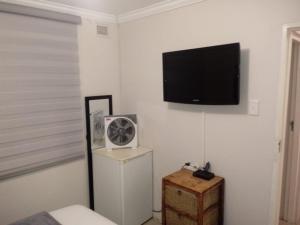 um quarto com uma televisão de ecrã plano na parede em Newlands East Home With A Beautiful View em Durban