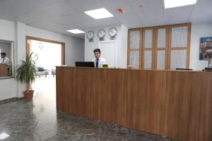 BEKSİTİ HOTEL في يالوفا: رجل يقف في مكتب الاستقبال في مكتب