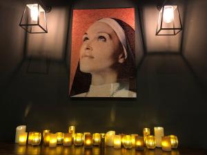 uma foto de uma mulher com velas num quarto em Guesthouse PoortAckere Ghent em Gent