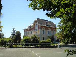 una grande casa con un campo da tennis di fronte ad essa di Domaine de Bassilour a Bidart Altre 110 foto