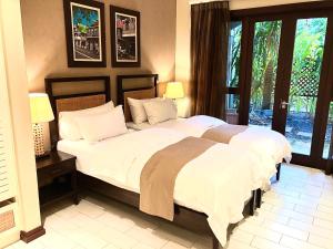 a bedroom with a large bed with white sheets and pillows at Eden Island Luxury Apartment - P14A3 in Eden Island
