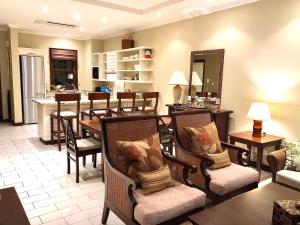 a living room with chairs and a dining room at Eden Island Apartment - P14A3 in Eden Island