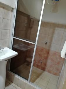 a shower with a glass door in a bathroom at Hospedaje Yaldai in Turrialba