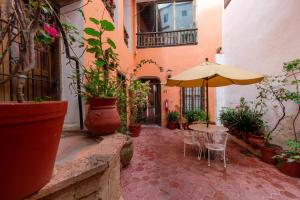 a patio with a table and an umbrella and potted plants at Hosteria del Frayle in Guanajuato