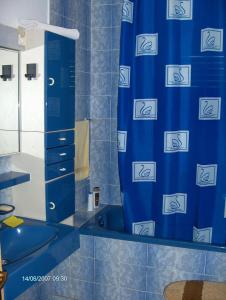 ein blaues Bad mit einem Duschvorhang und einem Waschbecken in der Unterkunft Rooms Miho - close to the sea in Vrboska