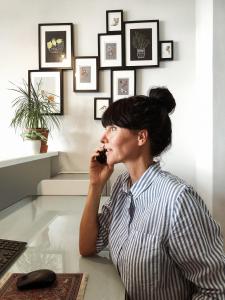 a woman sitting at a desk talking on a cell phone at Pension Absolut Berlin in Berlin